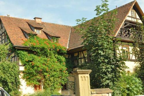 a large house with flowering plants in front of it at Gästezimmer - Fuhrhalterei Maul in Breuberg