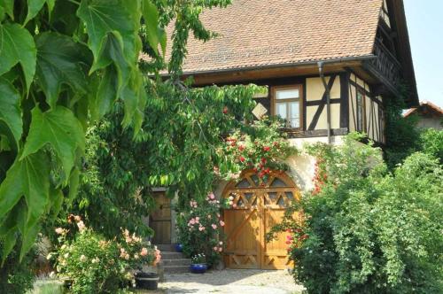 ein kleines Haus mit einer Holztür und Blumen in der Unterkunft Gästezimmer - Fuhrhalterei Maul in Breuberg