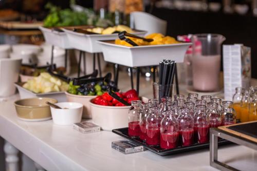 a buffet with drinks and bowls of fruits and vegetables at Movenpick Hotel Tallinn in Tallinn