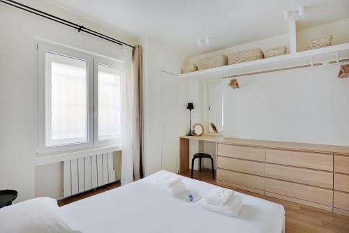 a white bedroom with a bed and a window at Amazing apartment - Sacre coeur in Paris