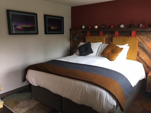 a bedroom with a large bed with white sheets and pillows at Dartmoor Halfway Inn in Newton Abbot