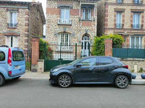 a small blue car parked in front of a building at Rez de chaussée et 1er étage et jardin dans Maison individuelle in Enghien-les-Bains