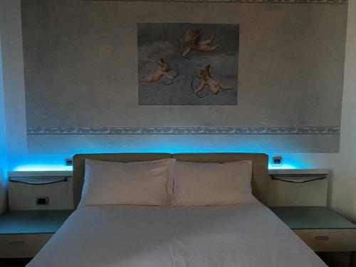 una camera con letto bianco e luce blu di Appartamento La Mansarda a Cerea