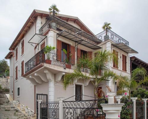 a white house with a palm tree in front of it at Angoni Villa in Durrës
