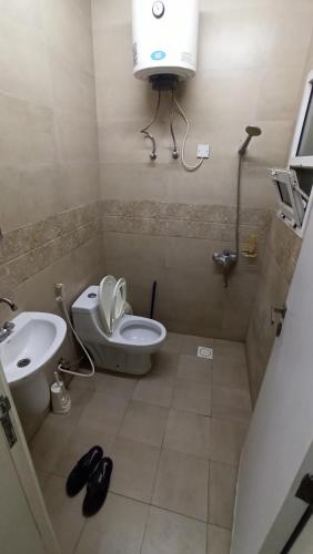 a small bathroom with a toilet and a sink at Budget Muscat Room in Seeb