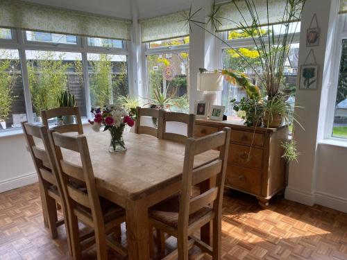 a dining room with a table and chairs and windows at Rooms in Hadleigh,Essex in Hadleigh