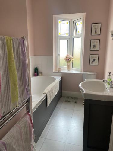 y baño con bañera y lavamanos. en Rooms in Hadleigh,Essex en Hadleigh