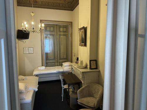 Habitación con 2 camas, mesa y silla en Hotel Rubenshof en Amberes