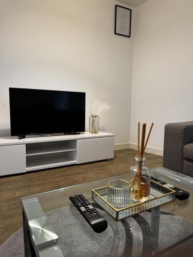een woonkamer met een flatscreen-tv op een entertainmentcentrum bij Greenwich Glamorous 2-Bed Apartment in Londen