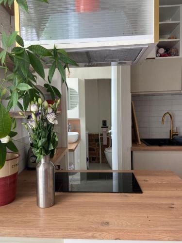 un vase de fleurs assis sur une table dans une cuisine dans l'établissement Grand studio 4 couchages Paris 14e, à Paris