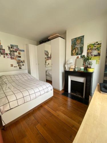 une chambre avec un lit et une cheminée dans l'établissement Grand studio 4 couchages Paris 14e, à Paris
