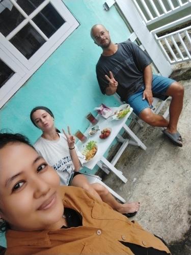 a group of people sitting around a table in a pool at Nio Homestay and Tour in Licin