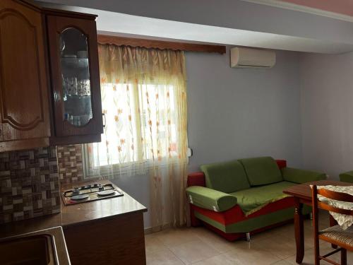 sala de estar con sofá verde en la cocina en Sea View Apartment Lungo Mare, en Vlorë