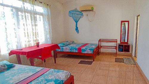 Monaragala的住宿－KING TOP Holiday Inn，一间设有两张床、一张桌子和一把椅子的房间