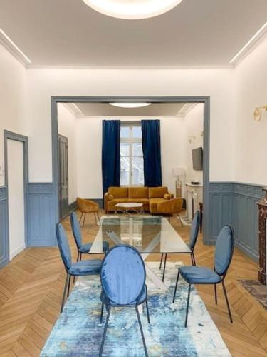 un salon avec une table en verre et des chaises dans l'établissement Appartement haut standing RDC, à Châteauroux