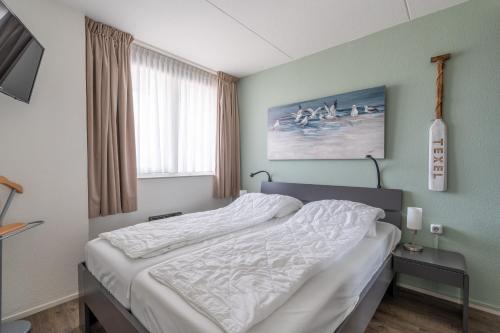 Un dormitorio con una cama grande en una habitación. en Appartementencomplex Juliana 88, en De Koog