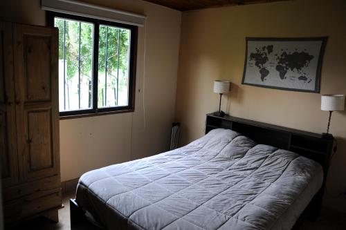 a bedroom with a bed and a window at Cabañas La Carmela Piedras B Potrerillos in Potrerillos