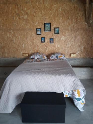 Cette chambre comprend un lit avec une couverture et des photos murales. dans l'établissement Le Manège, à Thiétreville