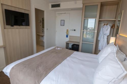 a bedroom with a large white bed and a window at Best Western Plus Le Roof Vannes Bord de Mer in Vannes