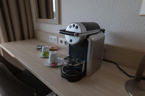 a coffee machine sitting on a table with a cup at Best Western Plus Le Roof Vannes Bord de Mer in Vannes