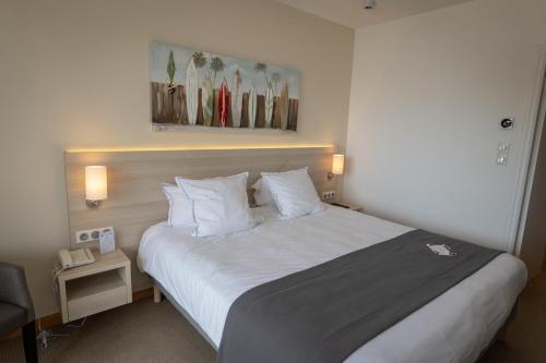 a hotel room with a large bed with white pillows at Best Western Plus Le Roof Vannes Bord de Mer in Vannes