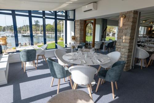 a restaurant with tables and chairs and a view of the water at Best Western Plus Le Roof Vannes Bord de Mer in Vannes