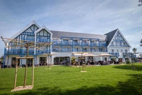 a large building with a lawn in front of it at Best Western Plus Le Roof Vannes Bord de Mer in Vannes