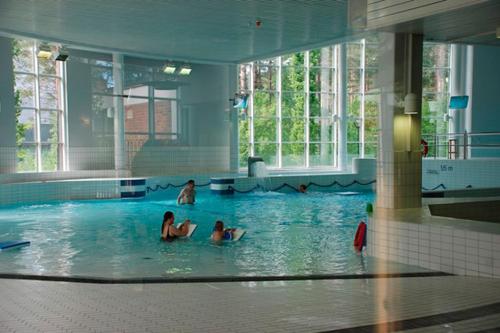two girls swimming in a swimming pool in a building at Docent's Flat in Joensuu