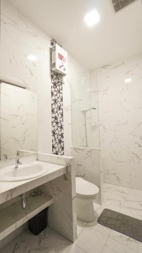 ein weißes Bad mit einem Waschbecken und einem WC in der Unterkunft Moniere House 2 in Kasri
