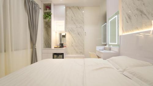 Dormitorio blanco con cama blanca y lavamanos en Moniere House 2 en Kasri