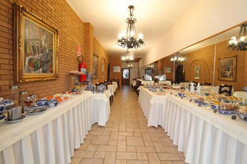 a row of tables with white table cloths at Pousada Villa Capivary Campos do Jordão in Campos do Jordão