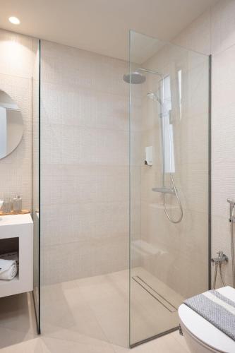 a glass shower in a bathroom with a toilet at Palm Tree Beach Suites, by ZanteWize in Alykes