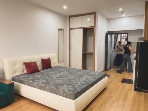 Dos personas de pie en una habitación con cama en Tropical land Little Hanoi apartment, en Hanói