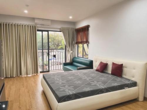 1 dormitorio con cama, sofá y ventana en Tropical land Little Hanoi apartment, en Hanói
