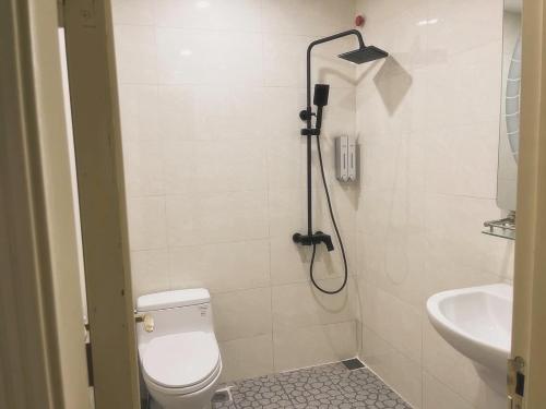 y baño con ducha, aseo y lavamanos. en Tropical land Little Hanoi apartment, en Hanói