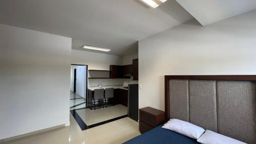 1 dormitorio con 1 cama y cocina. en Hotel Plazuela, en Cadereyta Jiménez