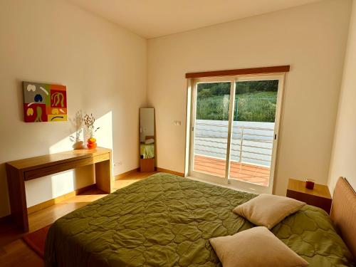 1 dormitorio con cama, escritorio y ventana en Vila Noélia en Albufeira
