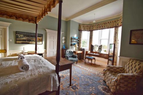 a bedroom with a canopy bed and a living room at Torloisk House in Kilninian