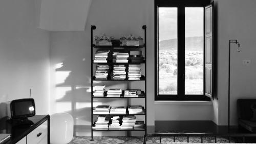 a room with a shelf of books and a window at Masseria Celeste in Fasano