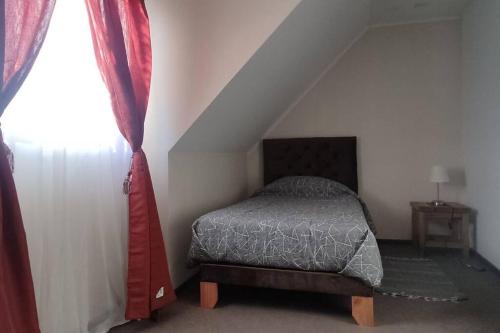 1 dormitorio con cama y ventana en Cómoda casa en Talca, en Talca