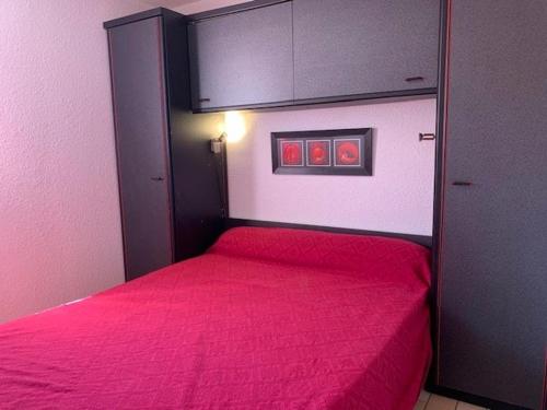 - une petite chambre avec un lit rouge dans l'établissement Villa Mitoyenne Calme avec Piscine, Jardin et Parking Privé, à Proximité de la Plage et Commerces - FR-1-607-33, au Cap d'Agde