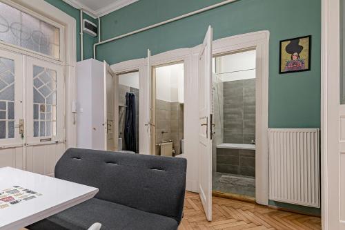 ein Wohnzimmer mit einem Stuhl und einer Dusche in der Unterkunft Downtown Rooms Wesselenyi in Budapest
