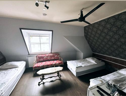 ドンブロヴァ・グルニチャにあるPałac Dąbrowaのベッド2台、椅子、窓が備わる客室です。