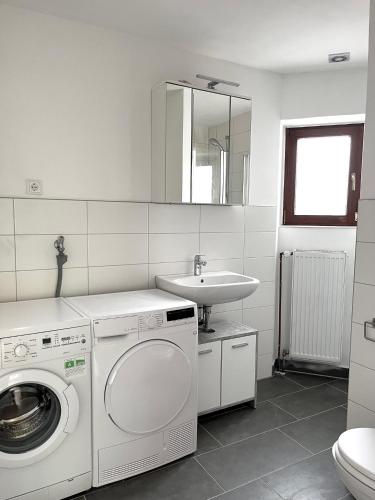 a bathroom with a washing machine and a sink at Schönes Zimmer zentral in Bremerhaven in Bremerhaven