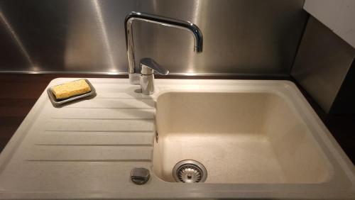 eine Küchenspüle mit einem Wasserhahn und einem Schwamm in der Unterkunft Le cocoon paisible avec garage au pied du Corbusier in Firminy