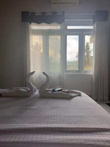 a bedroom with a bed with two swans on it at Kande Home in Kandy