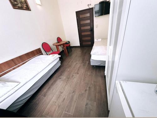 a room with two beds and a table and chairs at Pałac Dąbrowa in Dąbrowa Górnicza