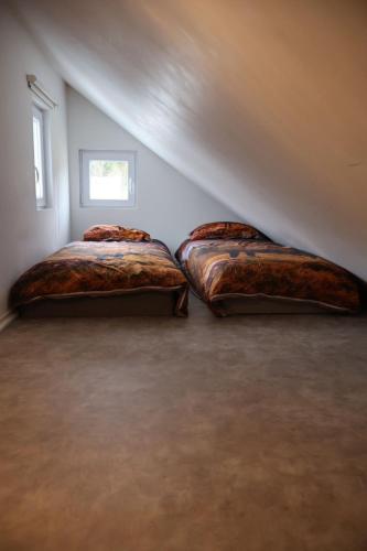 two beds in a room with a attic at Stuga Fyra Säsonger - Fishing - Skiing - Hottub in Filipstad