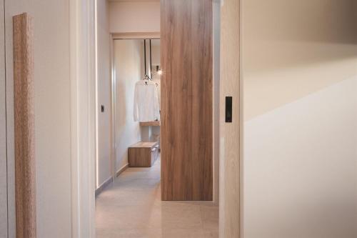 a hallway with a door leading to a closet with a robe at Palm Tree Beach Suites, by ZanteWize in Alykes