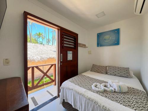 um quarto com uma cama e uma porta para uma varanda em Mini Hotel em Jericoacoara